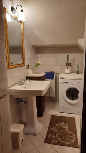 a bathroom with a sink and a washing machine at Podere Il Cerrone app Romilda con piscina in Fauglia