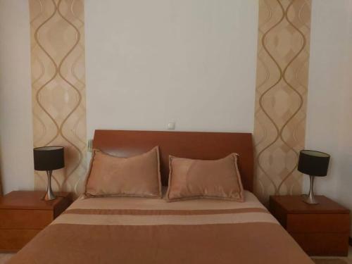 a bedroom with a large bed with two night stands at Apartamento acolhedor na Cidade da Praia in Praia