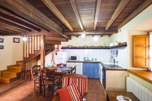 cocina con techos de madera, mesa y sillas en Ca PilaronaLa CuadraMallecina, en Salas