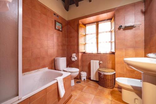 een badkamer met een bad, een toilet en een wastafel bij Ca PilaronaLa CuadraMallecina in Salas