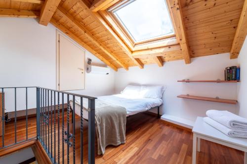 um pequeno quarto com uma cama e uma clarabóia em Green House Regatola by Wonderful Italy em Bellagio