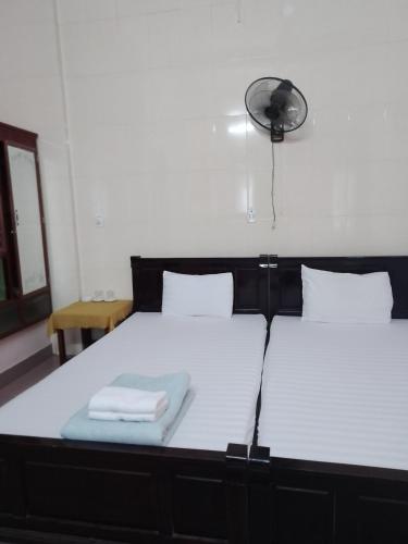 two beds with towels on top of them in a room at Nhà nghỉ Hằng Nga in Dong Hoi