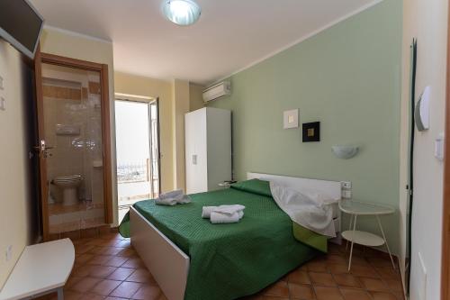 una camera con letto verde e doccia di Ravè a Praia a Mare