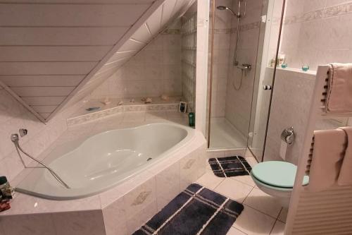 ein weißes Bad mit einer Badewanne und einem WC in der Unterkunft Behagliches Haus am Waldrand in Nähe von Berlin 