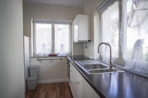 a white kitchen with a sink and a window at Vacation House Vila Mia in Bled