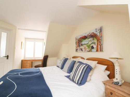 a bedroom with a large bed with blue and white pillows at Mayflower, 9 Coronation Road in Salcombe
