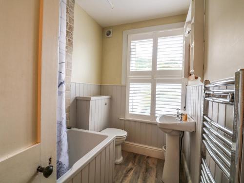 a bathroom with a tub and a toilet and a sink at Mayflower, 9 Coronation Road in Salcombe