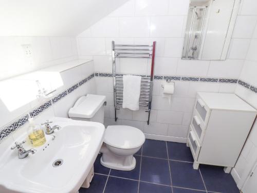 a white bathroom with a toilet and a sink at Lavender Cottage, Brailes in Lower Brailes
