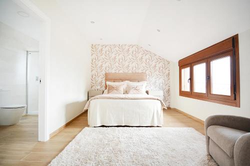 Habitación blanca con cama y alfombra en Luxury Dreams in Playa Paxariñas, en Sanxenxo