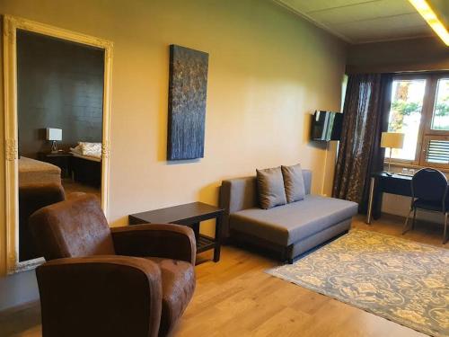 sala de estar con sofá y silla en Hotelli Viikinhovi en Keuruu