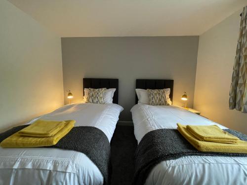 two beds sitting next to each other in a bedroom at Cosy & Comfortable Apartment w/Parking in Worksop