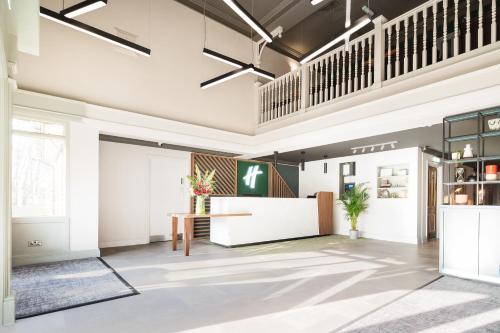 an office lobby with a reception desk and a staircase at Holiday Inn Reading West by IHG in Reading