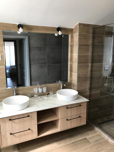 baño con 2 lavabos y espejo grande en Angyal Villa en Rátka
