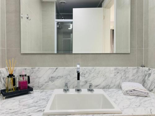 a bathroom with a white sink and a mirror at Lindo Loft UNID 212 in Sao Paulo