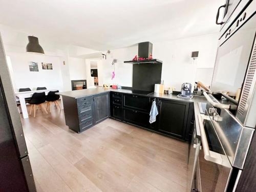 une cuisine avec des armoires noires et un comptoir dans l'établissement Magnifique duplex de 130 m² à Corte (centre ville), à Corte