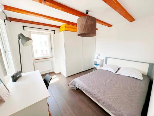 a bedroom with a bed and a desk and a window at Magnifique duplex de 130 m² à Corte (centre ville) in Corte