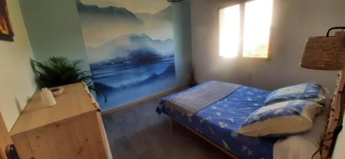 Chavanod的住宿－ISA ET LIO，卧室配有一张床,墙上挂有绘画作品