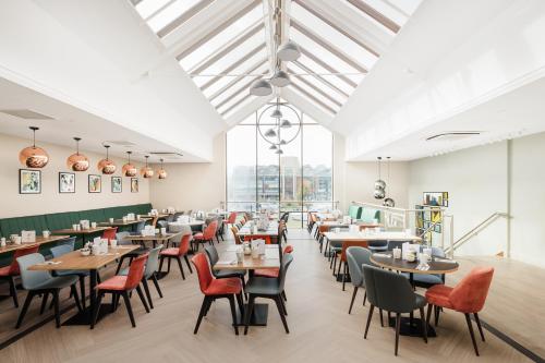 un comedor con mesas, sillas y ventanas en Holiday Inn Lincoln, an IHG Hotel, en Lincoln