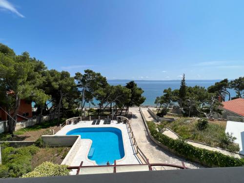 a swimming pool with the ocean in the background at Vila Vera Seafront Apartments in Sumartin