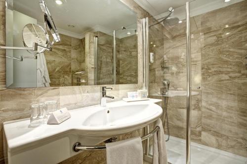 a bathroom with a tub, sink and mirror at Grupotel Gran Vista & Spa in Can Picafort