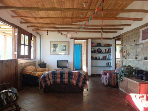 ein Wohnzimmer mit einem Sofa und einem TV in der Unterkunft El Refugio, Escape Rural in Gámbita