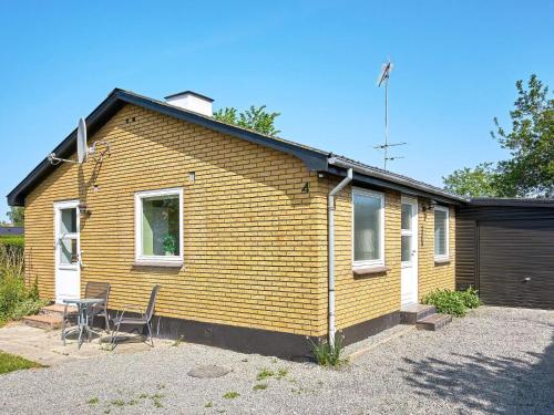a yellow house with a table and chairs in front of it at 6 person holiday home in Rønne-By Traum in Rønne