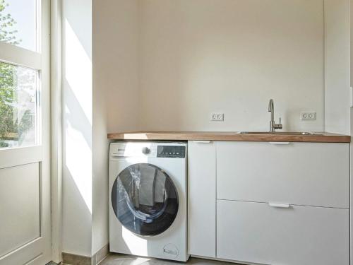a washing machine in a kitchen next to a window at 6 person holiday home in Rønne-By Traum in Rønne
