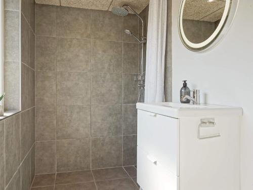 a bathroom with a shower with a sink and a mirror at Holiday home Rønne VI in Rønne