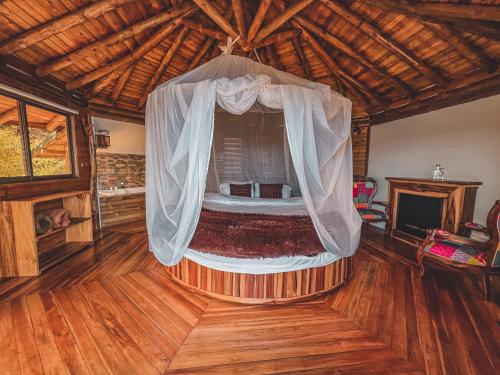a bedroom with a bed with a mosquito net at Costa Azul Ecolodge in Aquitania