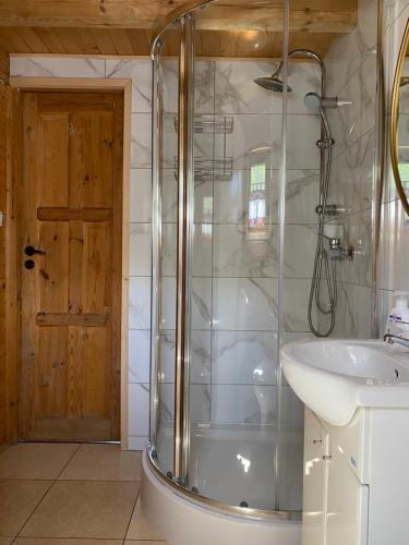 W łazience znajduje się prysznic i umywalka. w obiekcie Verde Land - Drewniany domek na wsi w mieście Osiek Mały