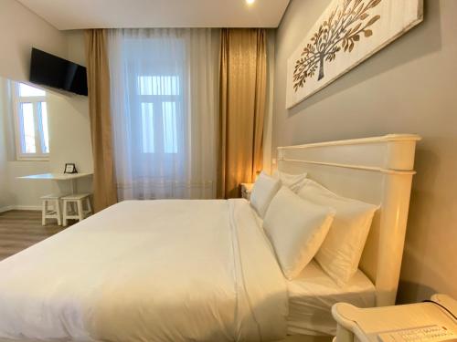Un dormitorio con una gran cama blanca y una ventana en Canto Doce, en Setúbal