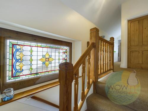 a staircase with a stained glass window in a house at Haslemere - Beer Devon in Beer