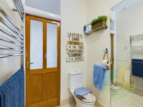 uma casa de banho com um WC e uma cabina de duche em vidro. em Haslemere - Beer Devon em Beer
