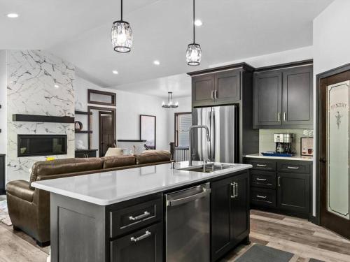 a kitchen with black cabinets and a living room at New, charming custom home in Sturgeon Bay