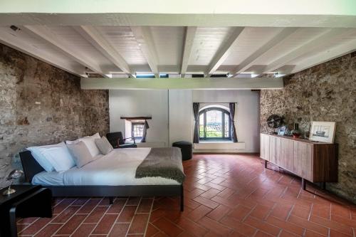 1 dormitorio con cama y pared de piedra en Casa Brocchi by Quokka 360 - unique design house with garden en Sorengo