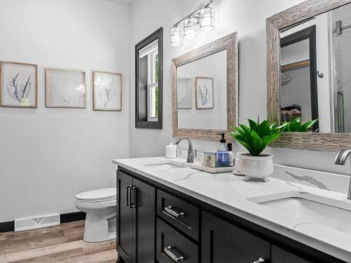 a bathroom with a sink and a toilet and mirrors at New, charming custom home in Sturgeon Bay