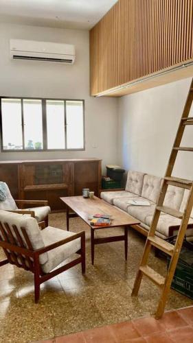 een woonkamer met een bank en een ladder bij Magical Apartment wBalcony @Jaffa in Tel Aviv