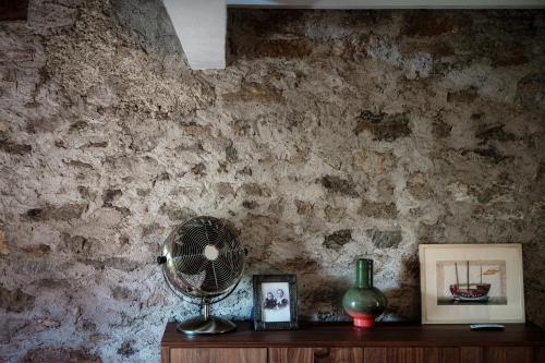 a fan sitting on a wooden table next to a wall at Casa Brocchi by Quokka 360 - unique design house with garden in Sorengo