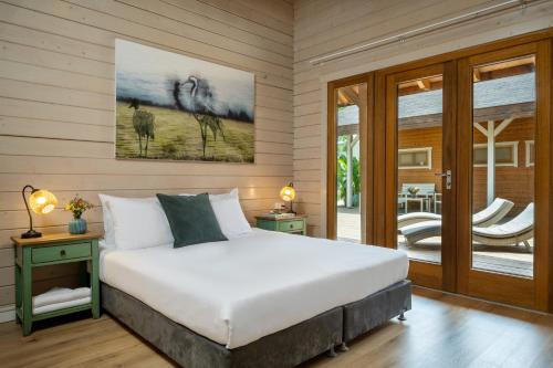 a bedroom with a large bed and a patio at The Jordan River Villa by Travel Hotels Group in Sede Neẖemya