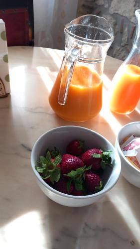 a bowl of strawberries and a jar of orange juice at B&b Diamante and home restaurant in Trentinara