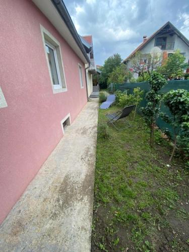 a pink building next to a yard next to a house at APARTMAN MILICA in Požarevac