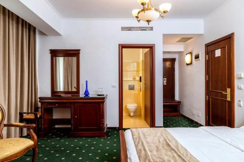 a hotel room with a bed and a bathroom at Hotel Victoria in Piteşti