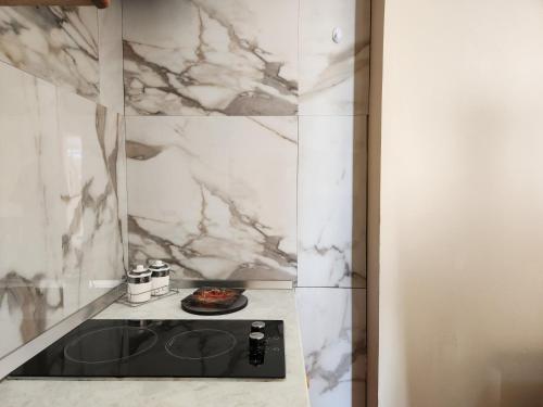 a kitchen with a black counter and marble walls at Villa Orange in Vlorë