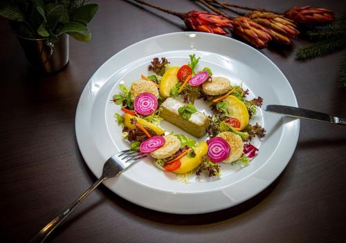 a plate of food with vegetables on a table at Hotel Grand Jasná in Demanovska Dolina