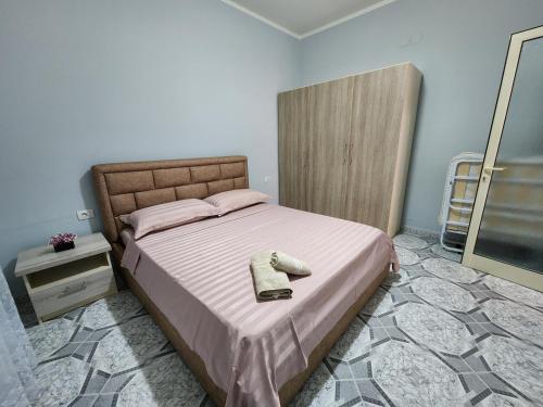 a bedroom with a large bed with pink sheets and a mirror at Villa Bleta in Vlorë