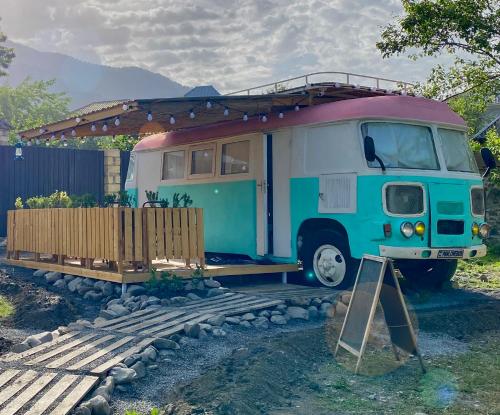 a blue and pink van parked next to a fence at Pavlove Tiny Bus House in Qabala in Gabala