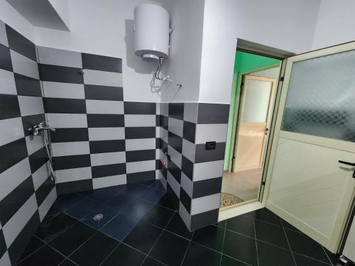 a bathroom with a black and white checkered wall at Villa Orange in Vlorë