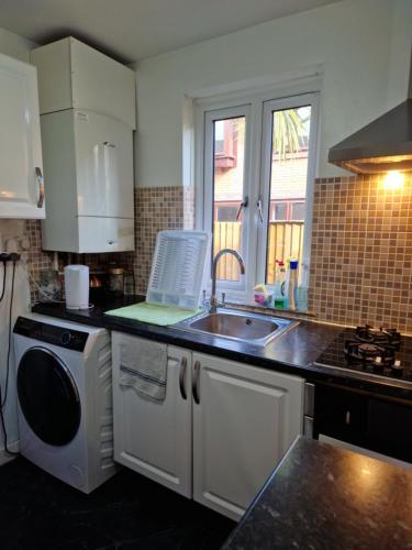 a kitchen with a sink and a dishwasher at COZY DOUBLE BEDROOM IN ZONE 1-2 CENTRAL LONDON in London