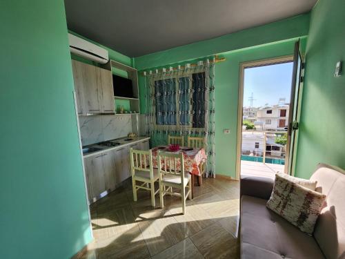 a kitchen and dining room with green walls and a table at Villa Bleta in Vlorë