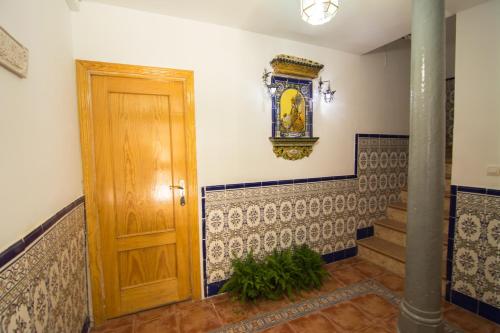 a hallway with a wooden door and tiles at San José Guest House in Granada